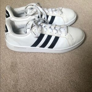 Adidas three striped tennis shoes.